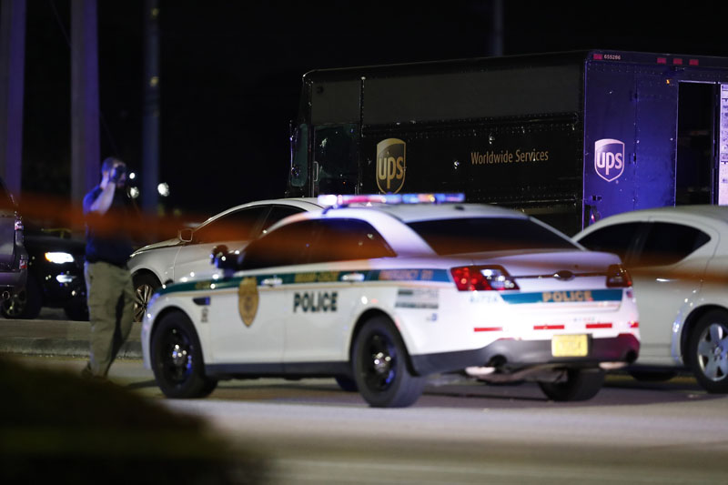 Authorities walk near a UPS truck and other vehicles at the scene of a shooting, Thursday, Dec 5, 2019, in Miramar, Florida. Photo: AP