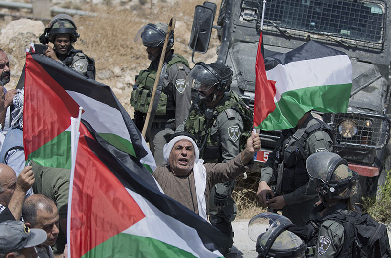 Israeli border police block the road and disperse Palestinian, Israeli and foreign activists during a rally protesting a newly established settlement near the West Bank village of Kufr Malik, East of Ramallah. File Photo: AP