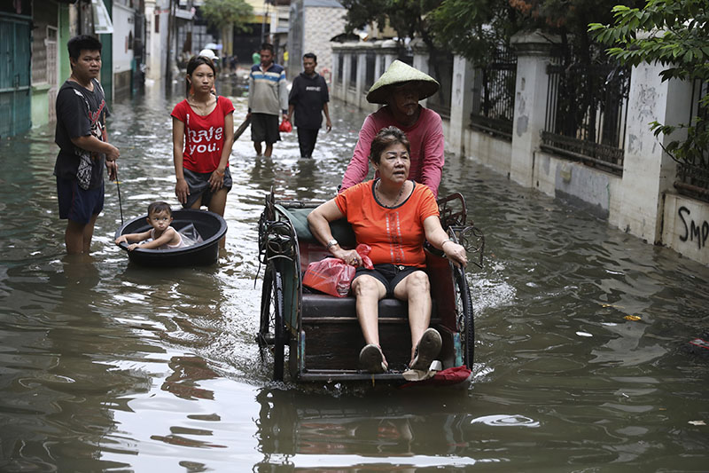 A woman rides a tricycle on a flooded street in Jakarta, Indonesia, Saturday, Jan. 4, 2020. Photo: AP