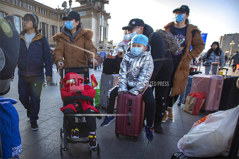 Travelers wear face masks as they walk outside of the Beijing Railway Station in Beijing, Monday, Jan. 20, 2020. Photo: AP