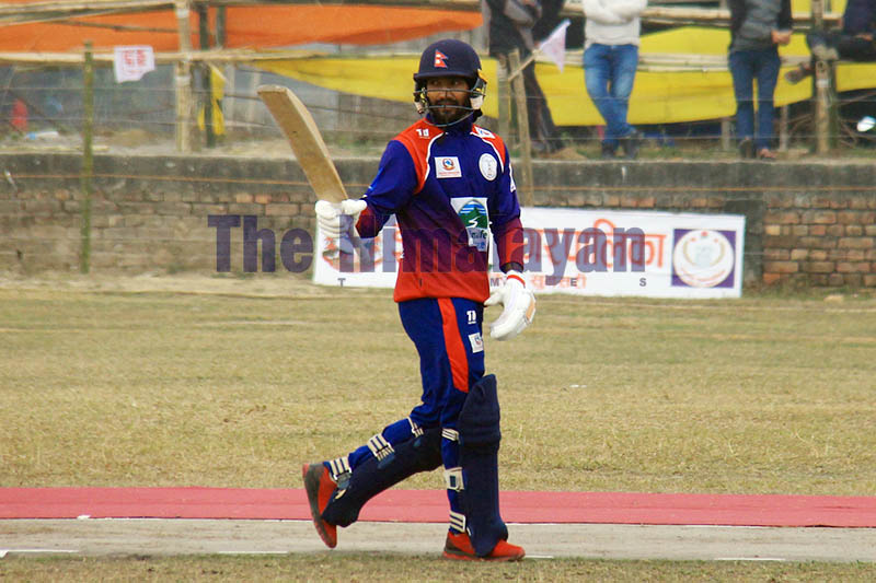 Nepal Police batsman Dipendra Singh Airee raises his bat to acknowledge the crowd after hitting 50 runs during Manmohan Memorial National Cricket Tournament in Sunsari, on Friday, January 10, 2020. Photo: Santosh Kafle/THT