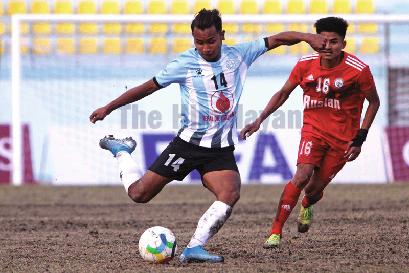 MMCu2019s Anjan Bista (left) shoots the ball under pressure from Ruslan TSCu2019s Sanjog Rai during their Qatar Airways Martyrs Memorial A Division League match in Kathmandu on Saturday. Photo: Udipt Singh Chhetry/THT