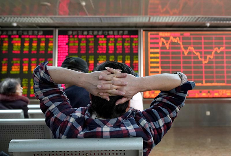 An investor looks at a stock quotation board at a brokerage office in Beijing, China, on January 3, 2020. Photo: Reuters