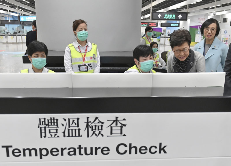 FILE - Hong Kong Chief Executive Carrie Lam, second from right, accompanied by Secretary for Food and Health, Prof Sophia Chan, right, reviews the health surveillance measures by officers of the Port Health Division at West Kowloon Station in Hong Kong, Friday, Jan 3, 2020. Photo: Hong Kong Government Information Service via AP