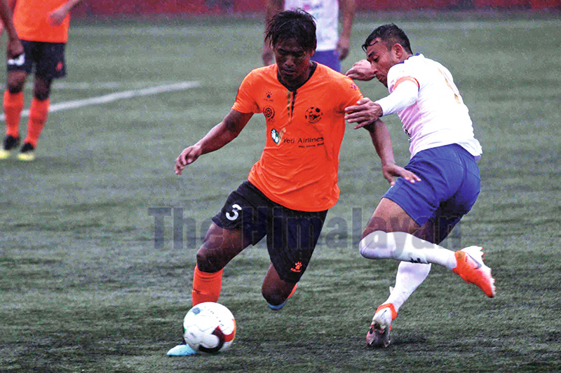 Ashish Gurung (left) of Himalayan Sherpa Club dribbles the ball against Sujal Shrestha of Machhindra Club during their Qatar Airways Martyr's Memorial Division League match at ANFA ground, Satdobato in Lalitpur on Friday. Photo: Udipt Singh Chhetry/THT
