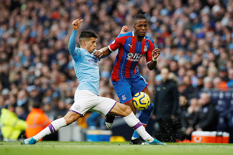 Manchester City's Joao Cancelo in action with Crystal Palace's Wilfried Zaha. Photo: Reuters