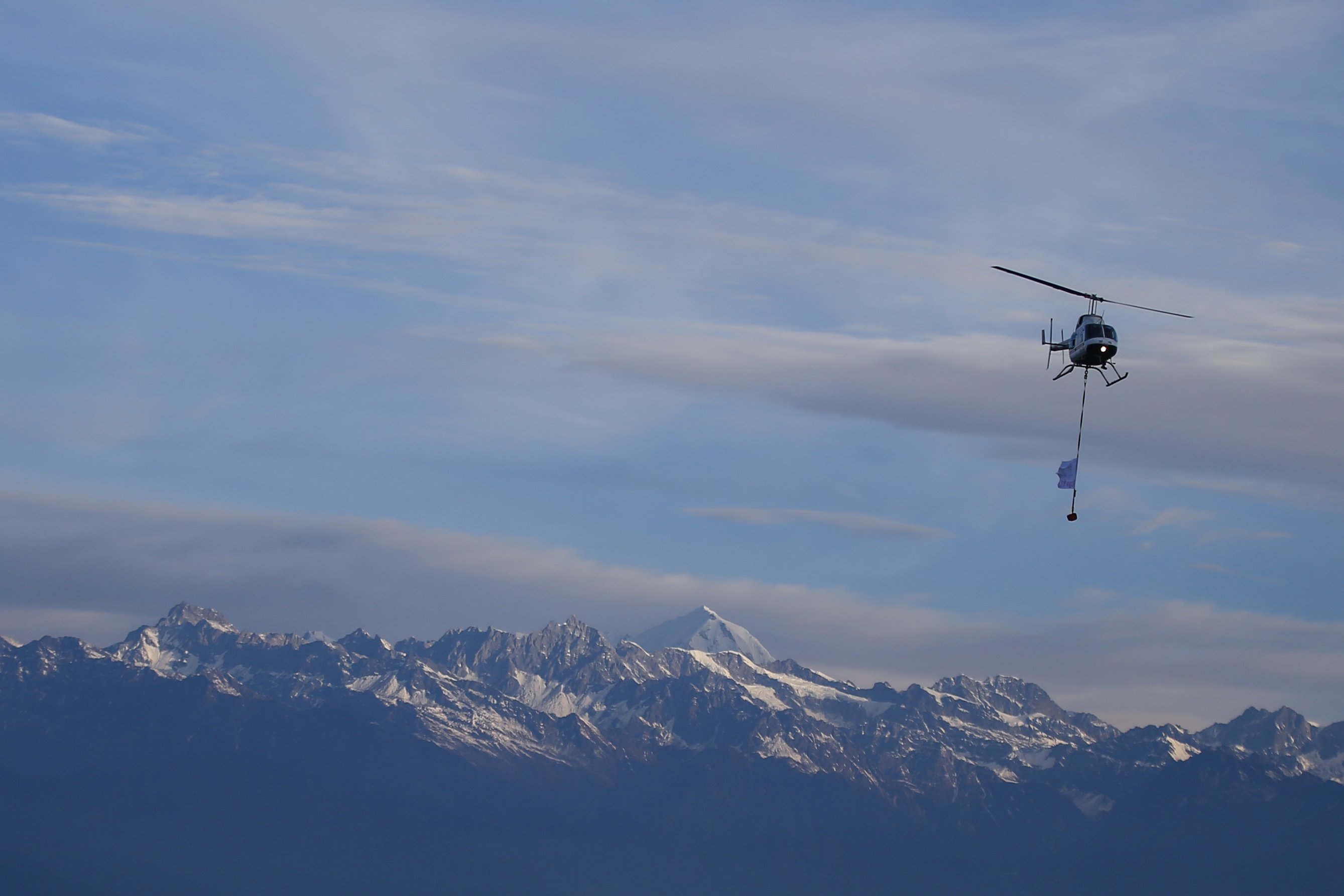 A helicopter showering flowers is pictured against the backdrop of a mountain range during the Visit Nepal-2020 New Year campaign, at Nagarkot, on Wednesday, January 1, 2020. Photo: Skanda Gautam/THT