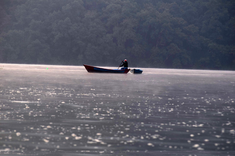 A person paddles a boat drifting on Phewa Lake, Pokhara. Photo Courtesy: Rabin Gautam
