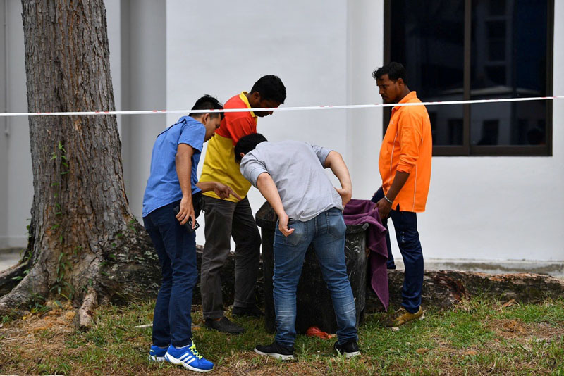 FILE PHOTO: Police officers and cleaners inspect the contents of a bin at a rubbish chute, after a baby was found alive among rubbish in a bin at a public housing estate in Singapore, January 7, 2020. Photo: AP