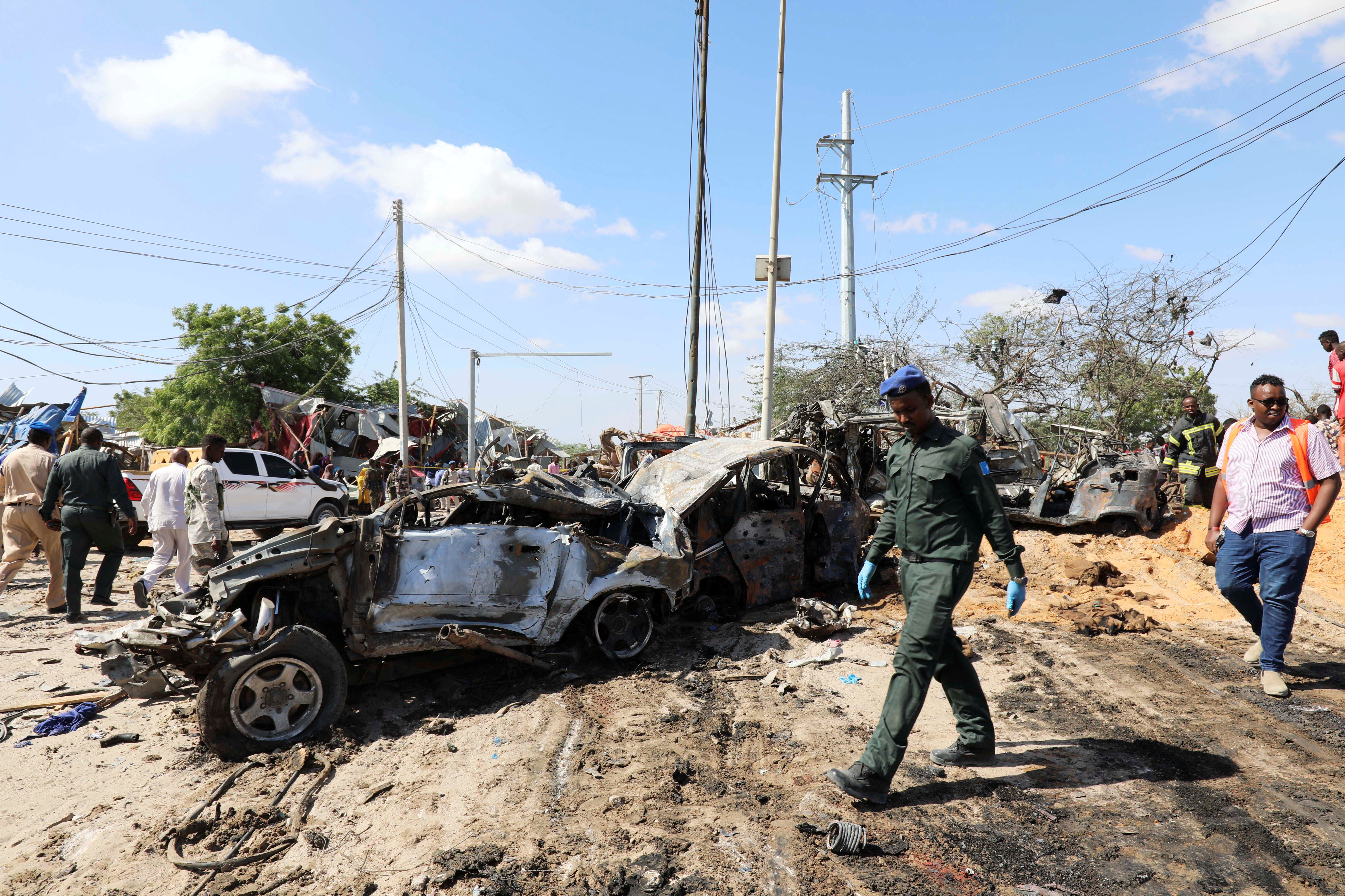 A Somali police officer walks past a wreckage at the scene of a car bomb explosion at a checkpoint in Mogadishu, Somalia  December 28, 2019. Photo: Reuters