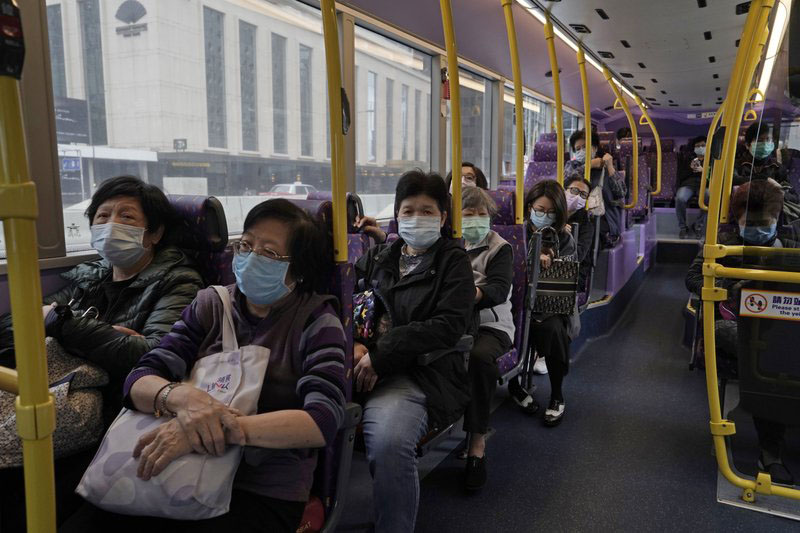 Passengers wears face masks as a precaution against the COVID-19 while sitting in a bus in Hong Kong, Thursday, Feb. 27, 2020. Photo: AP