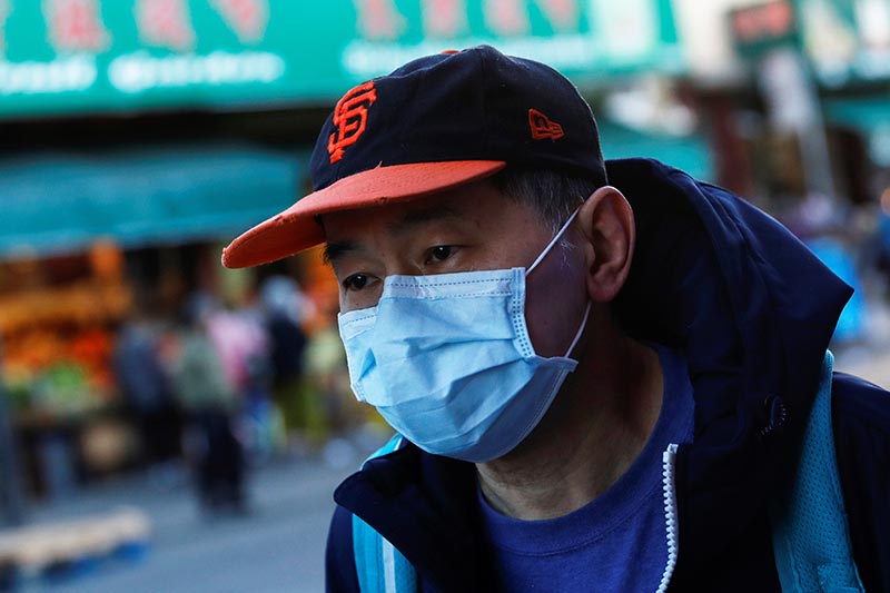 A man wears a face mask while waiting for a public bus in the Chinatown section of San Francisco, California, US, February 25, 2020. Photo: Reuters