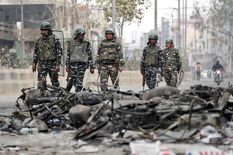 Security forces patrol past charred vehicles in a riot affected area following clashes between people demonstrating for and against a new citizenship law in New Delhi, India, February 27, 2020. Photo: Reuters