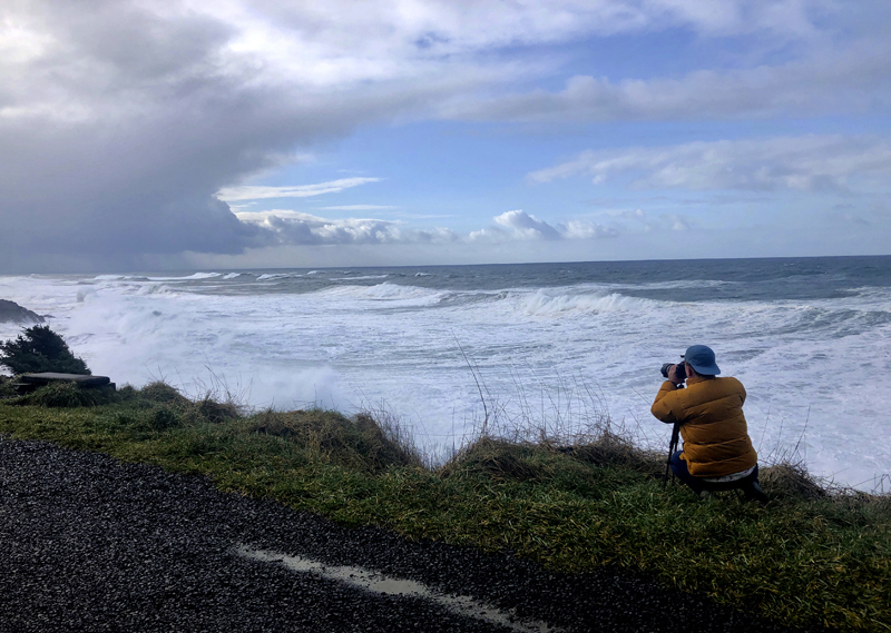 A man photographs waves crashing onto the cliffs at Rodea Point in Lincoln County, Oregon during an extreme high tide that coincided with a big winter storm, Jan 11, 2020. Photo: AP