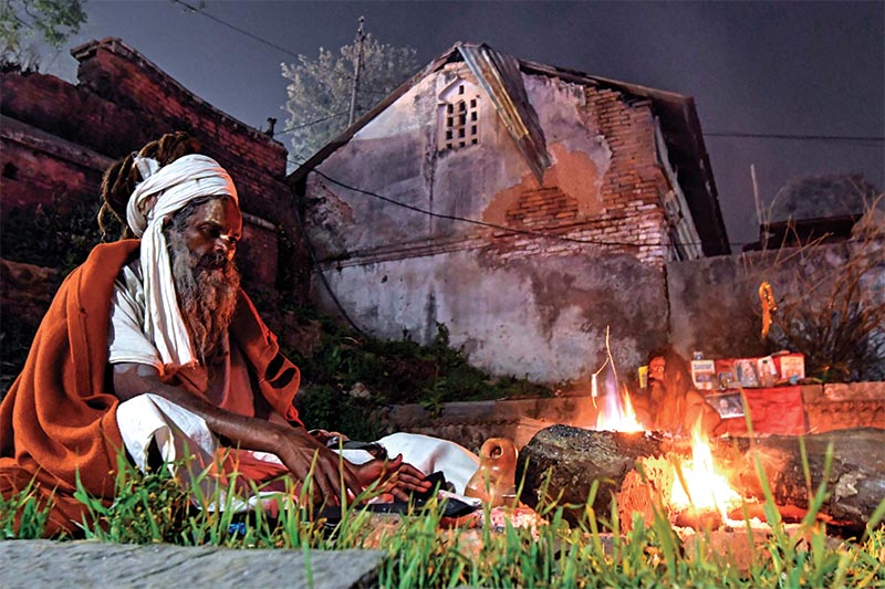 A sadhu sitting next to a bonfire near Pashupatinath temple, on Friday, February 21, 2020. The festival is also celebrated during night by keeping a night-long vigil as it is believed that lord Shiva saved the universe from darkness and ignorance. Photo: AFP