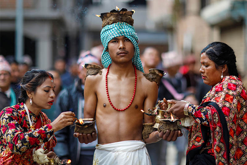 Devotees with lit oil lamps perform religious rituals during the Swasthani Brata Katha festival at Thecho in Lalitpur, on Thursday, February 6, 2020. Photo: Reuters