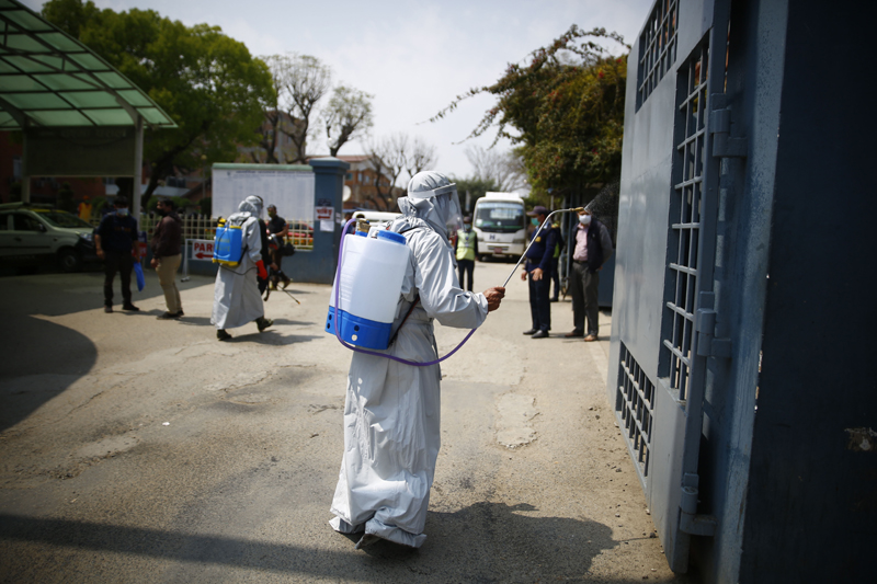 Health workers wearing personal protective suits disinfect the Patan Hospital premises on the third day of the nationwide lockdown amid concerns over the spread of coronavirus infection (COVID-19), in Lalitpur, on Thursday, March 26, 2020. Photo: Skanda Gautam/THT