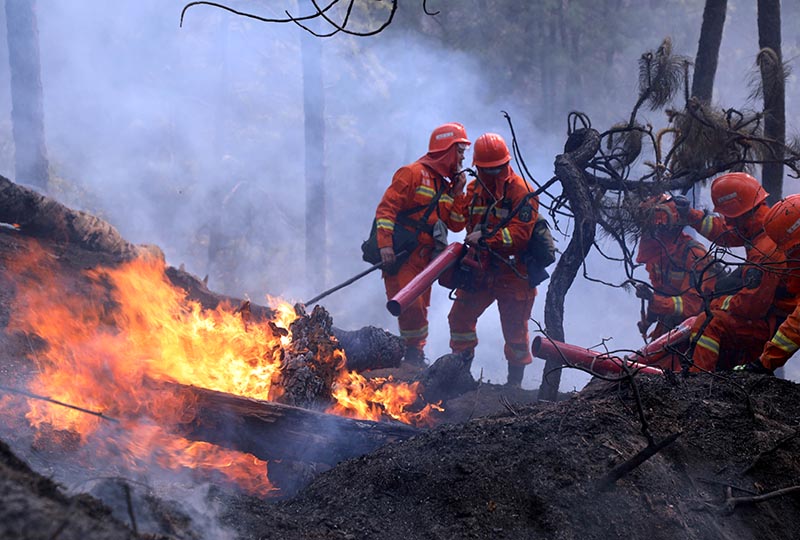 Firefighters work on extinguishing a forest fire that started near Xichang in Liangshan prefecture of Sichuan province, China March 31, 2020. Photo: China Daily via Reuters