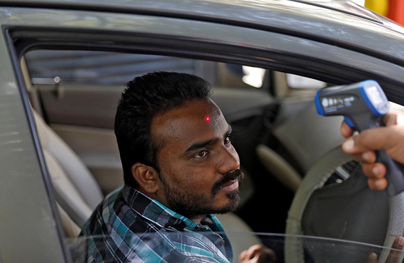 A man arriving into an office building gets his temperature measured by a private security guard using an infrared thermometer, following an outbreak of the coronavirus disease, in New Delhi, India, March 9, 2020. Photo: Reuters