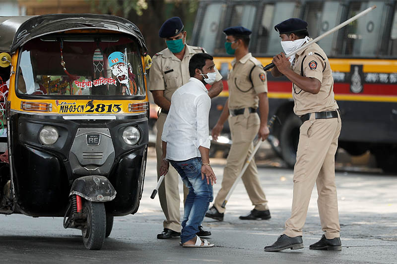A policeman wields his baton at an autorickshaw rider as punishment for breaking the lockdown rules, after India ordered a 21-day nationwide lockdown to limit the spreading of coronavirus disease (COVID-19) in Mumbai, India March 25, 2020. Photo: Reuters