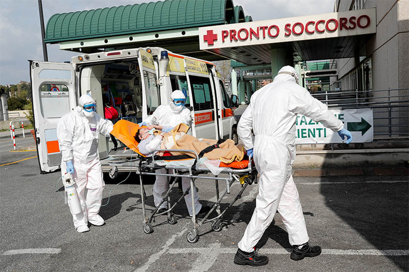 Medical workers in protective suits push a patient on a stretcher in front of the Policlinico Tor Vergata, where patients suffering from coronavirus disease (COVID-19) are hosted, in Rome, Italy March 30, 2020. Photo: Reuters
