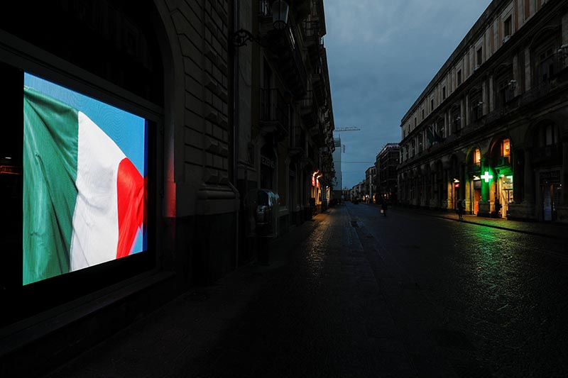 A screen displaying the Italian flag is pictured on an empty street, after Italy reinforced the lockdown measures to combat the coronavirus disease (COVID-19) in Catania, Italy March 21, 2020. Photo: Reuters