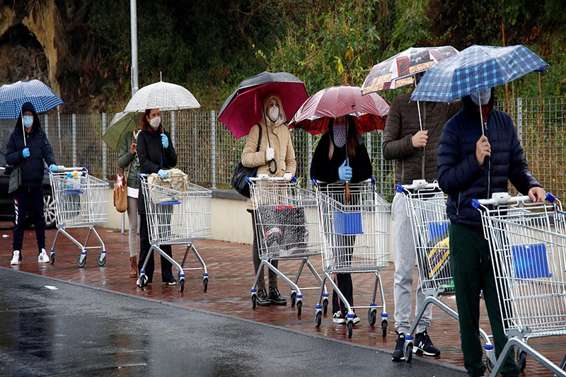 FILE - People line up in the rain outside a supermarket after the Italian island of Sicily closed them on Sunday, as it tightens measures to try and contain the spread of coronavirus disease (COVID-19), in Catania, Italy March 23, 2020. Photo: Reuters