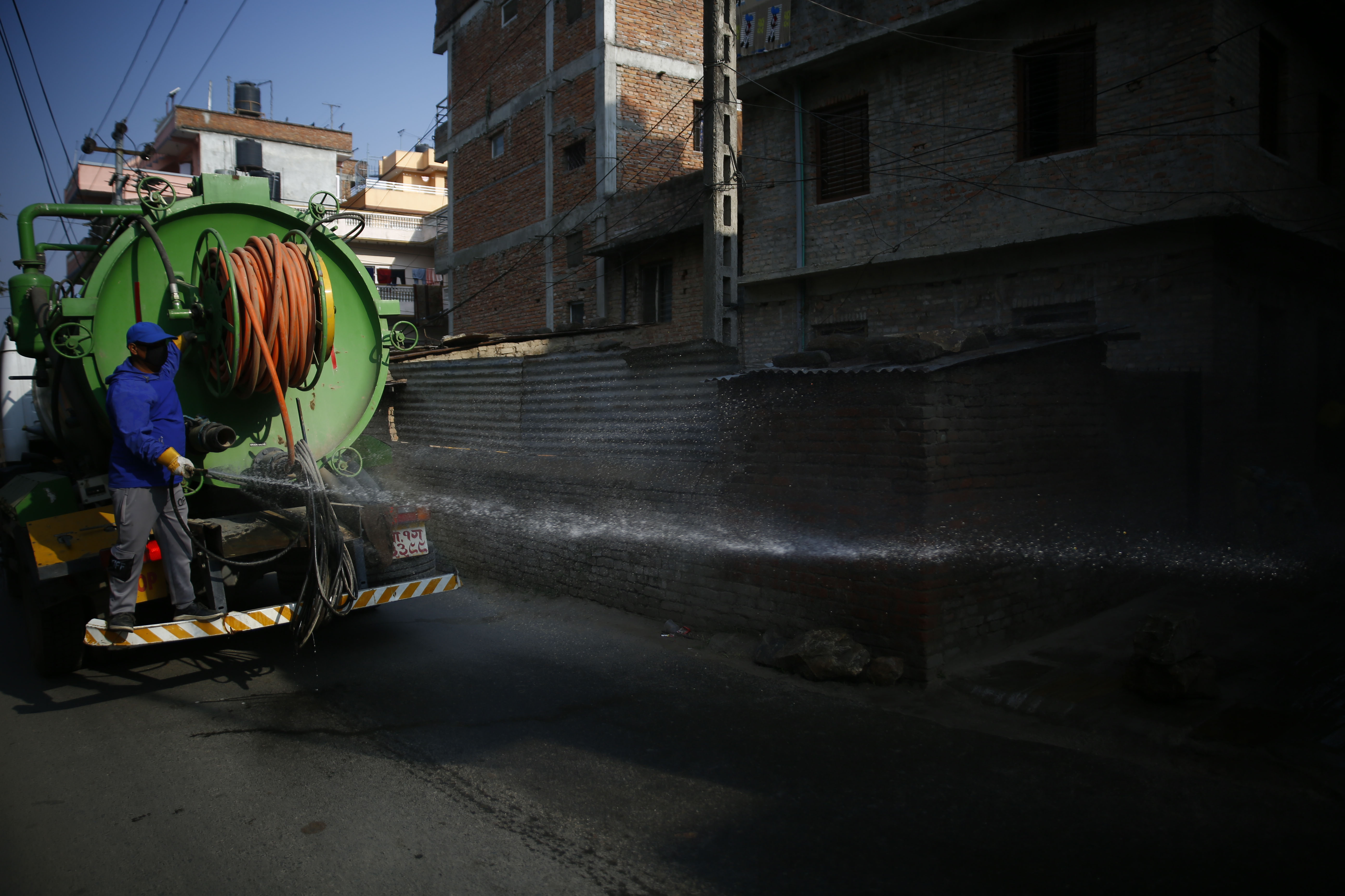 A metropolitan city worker disinfects a street amid concerns over the spread of coronavirus infection, on the fourth day of government-imposed lockdown, in Kathmandu, on Friday, March 27, 2020. Photo: Skanda Gautam/THT