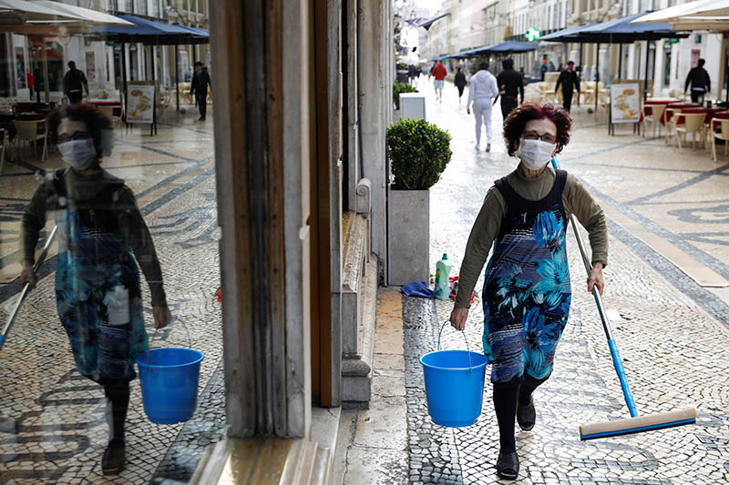 A cleaner is pictured wearing a mask, as she works at a shop in downtown Lisbon, Portugal March 16, 2020.  Photo: Reuters