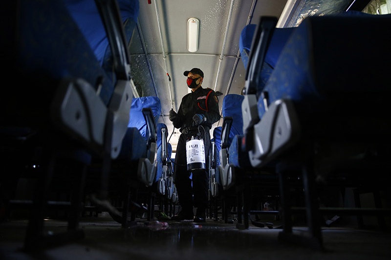 A security guard disinfects a Sajha Yatayat public transportation bus amid concerns over the spread of coronavirus outbreak, in Lalitpur, on Tuesday, March 17, 2020. Photo: Skanda Gautam/THT