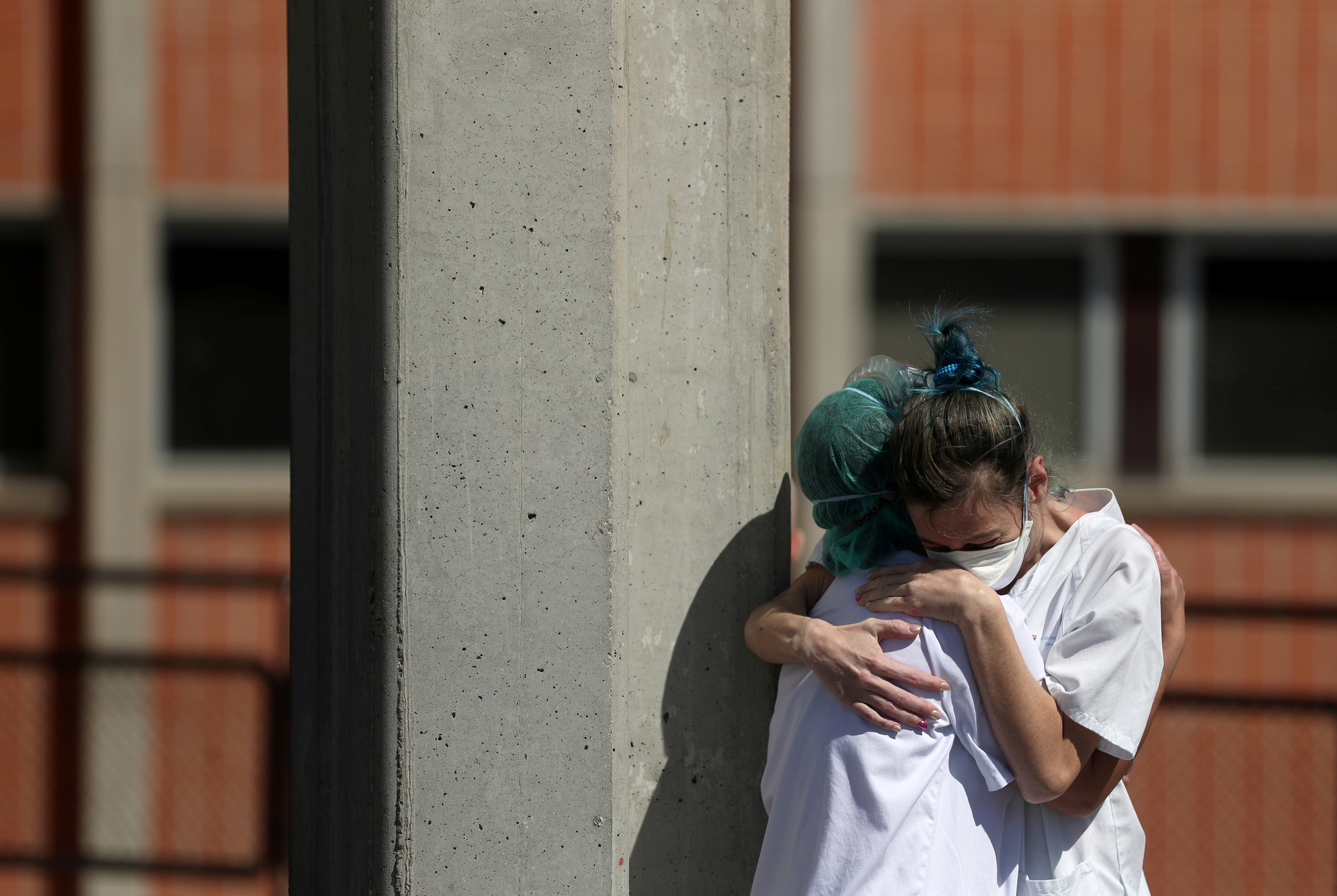 Medical wokers hug eachother outside the emergency rooms at Severo Ochoa Hospital during the coronavirus disease (COVID-19) outbreak in Leganes, Spain, March 26, 2020. Photo: Reuters