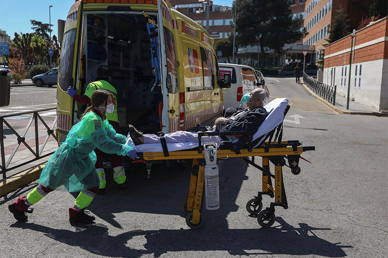 A healthcare worker wearing a protective face mask and suit transports a patient from an ambulance to the emergency unit at 12 de Octubre hospital during the coronavirus disease (COVID-19) outbreak in Madrid, Spain March 28, 2020. Photo: Reuters