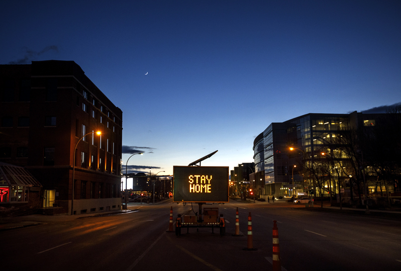 A sign telling people how to help slow the spread of COVID-19 by staying home, sits on an the empty downtown street in Edmonton, Alberta, Thursday, March 26, 2020. Photo: Jason Franson/The Canadian Press via AP