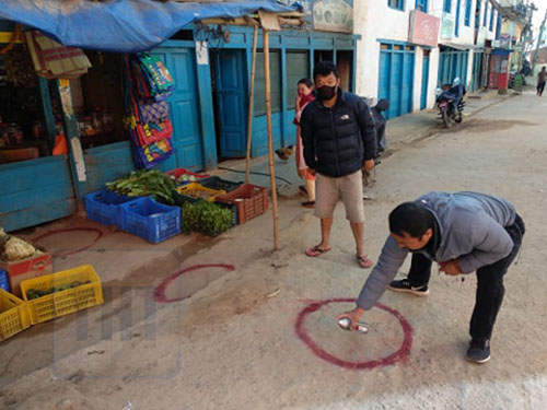 Locals painting circle in front of a grocery store to follow safe physical distancing while shopping for essential items, in Bhojpur district, on Monday, March 30, 2020. Photo: Niroj Koirala/THT