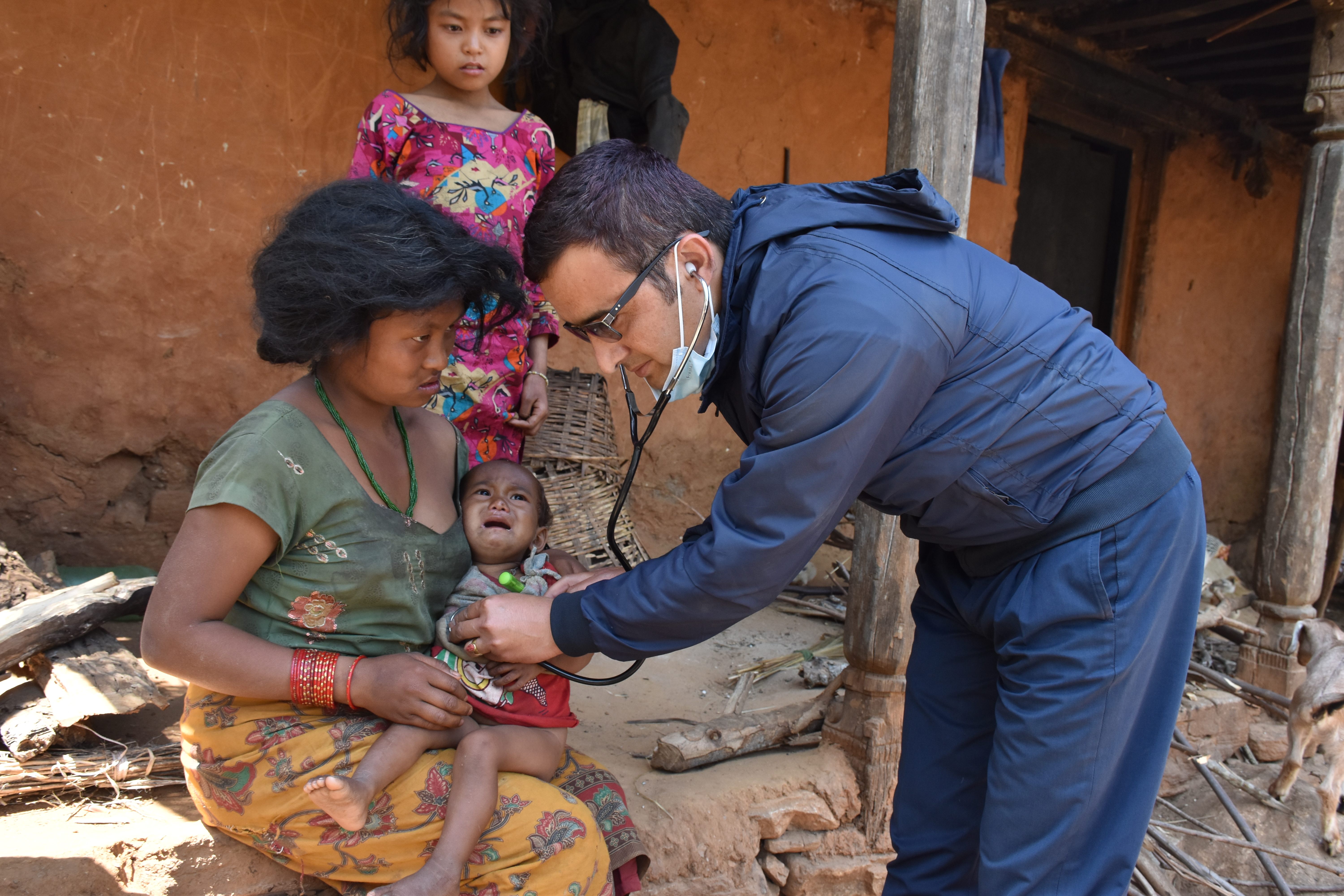 Health Coordinator Shankar Babu Dawadi of Benighat Rural Municipality examining a child following the outbreak of measles-rubella in Dhading, on Sunday, April 6, 2020. Photo: Keshav Adhikari/THT