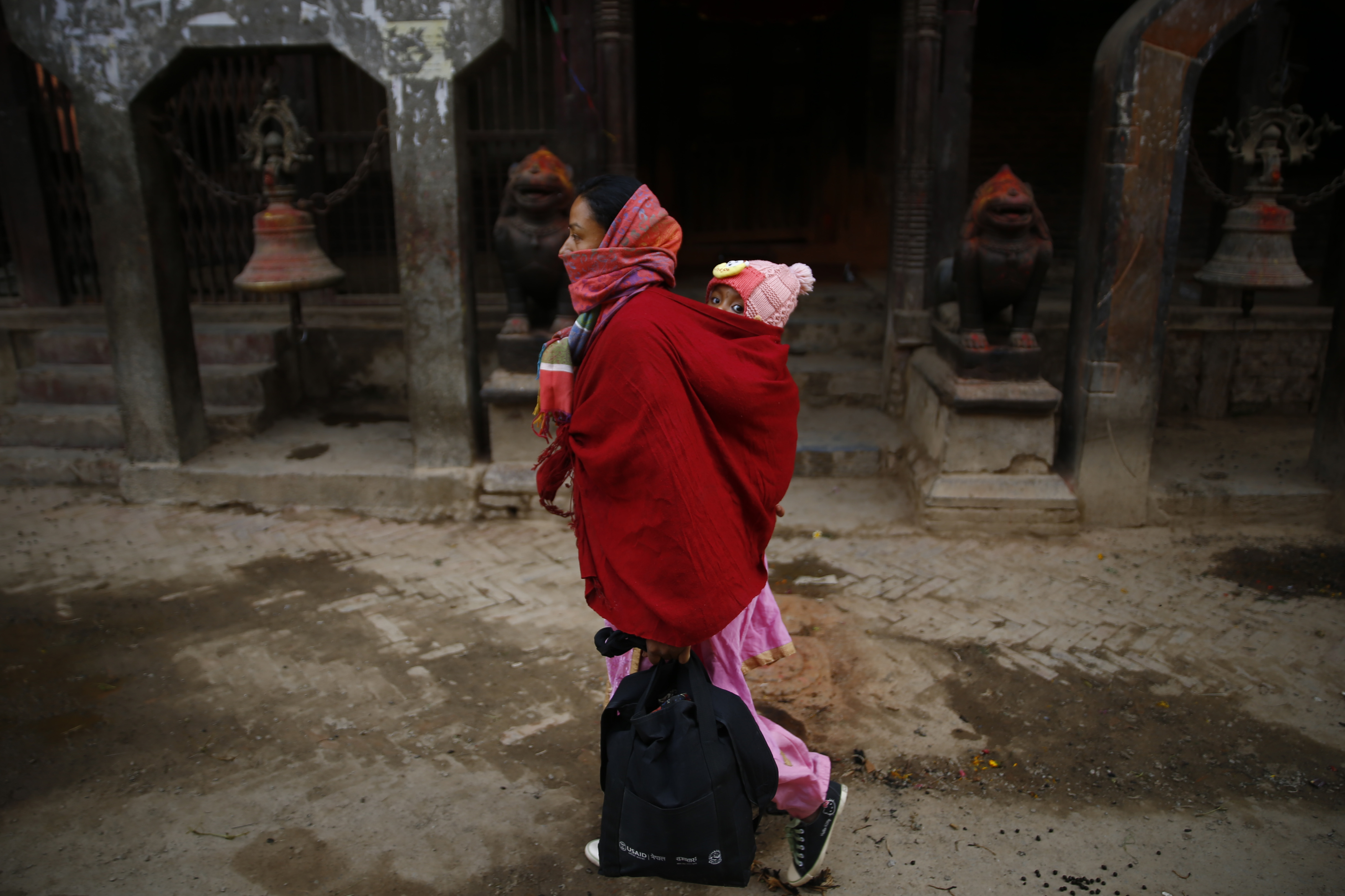 A woman and a child with their faces covered walk along their village on the sixteenth day of the government-imposed lockdown, amid concerns over the spread of COVID-19 contagion, in Lalitpur, on Wednesday, April 08, 2020. Photo: Skanda Gautam/THT