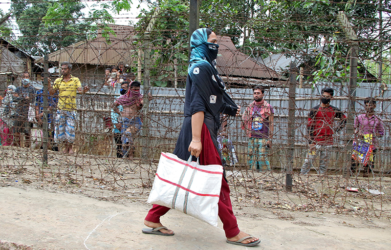 A woman, who lives near India-Bangladesh international border, carries a bag with free grocery items distributed by government officials during an extended nationwide lockdown to slow the spreading of coronavirus disease (COVID-19), at Joynagar village, on the outskirt of Agartala, India, April 17, 2020. Photo: Reuters