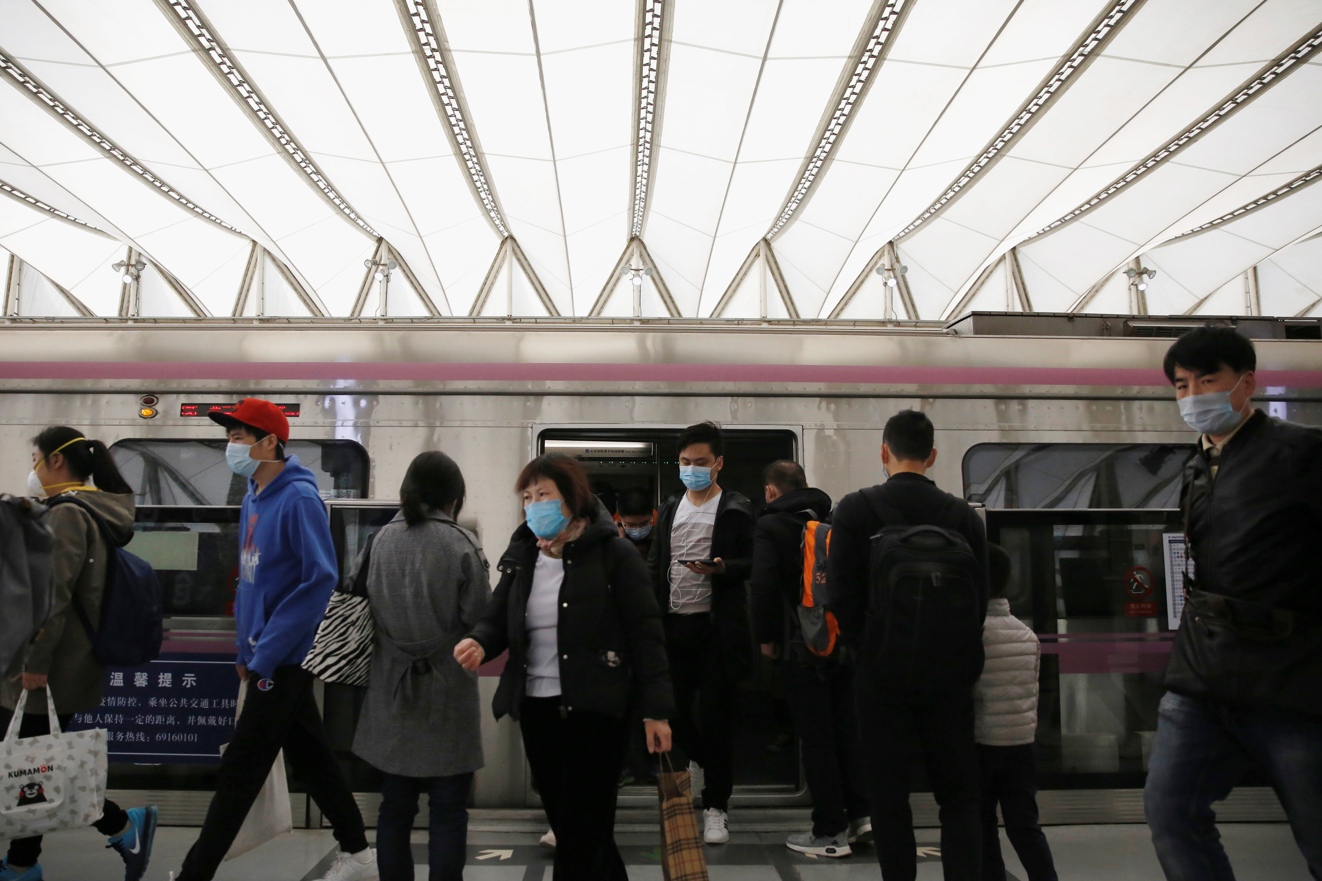 People wearing face masks get off a subway train at a subway station during morning rush hour in Beijing, as the spread of the novel coronavirus disease (COVID-19) continues in the country, in China, on April 7, 2020. Photo: Reuters