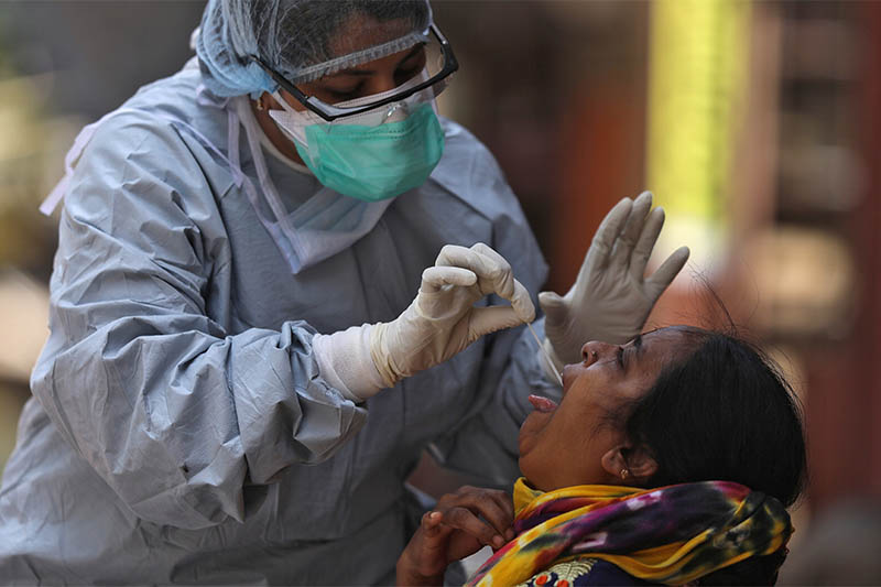 A doctor wearing a protective gear takes a swab from a woman to test for coronavirus disease (COVID-19), in Dharavi, one of Asia's largest slums, in Mumbai, India, April 9, 2020. Photo: Reuters