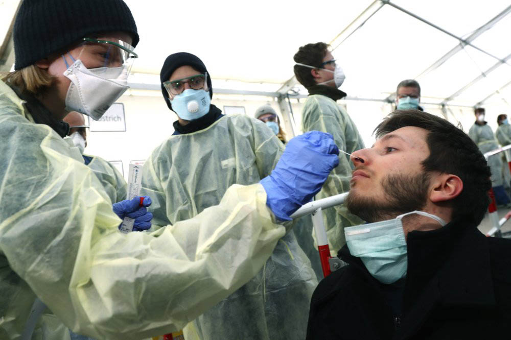 FILE - In this March 23, 2020, file photo, medical employees demonstrate testing, at a coronavirus test center for public service employees, during a media presentation in Munich, Germany. Photo: AP