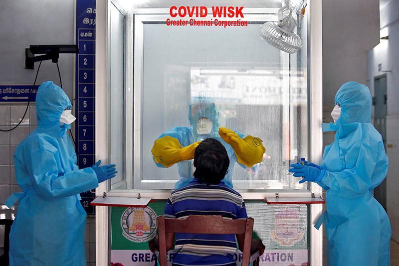 FILE - A doctor in a protective chamber takes a swab from a man to test for coronavirus disease (COVID-19) at a newly installed Walk-In Sample Kiosk (WISK) in a government-run hospital in Chennai, India, April 13, 2020. Photo: Reuters