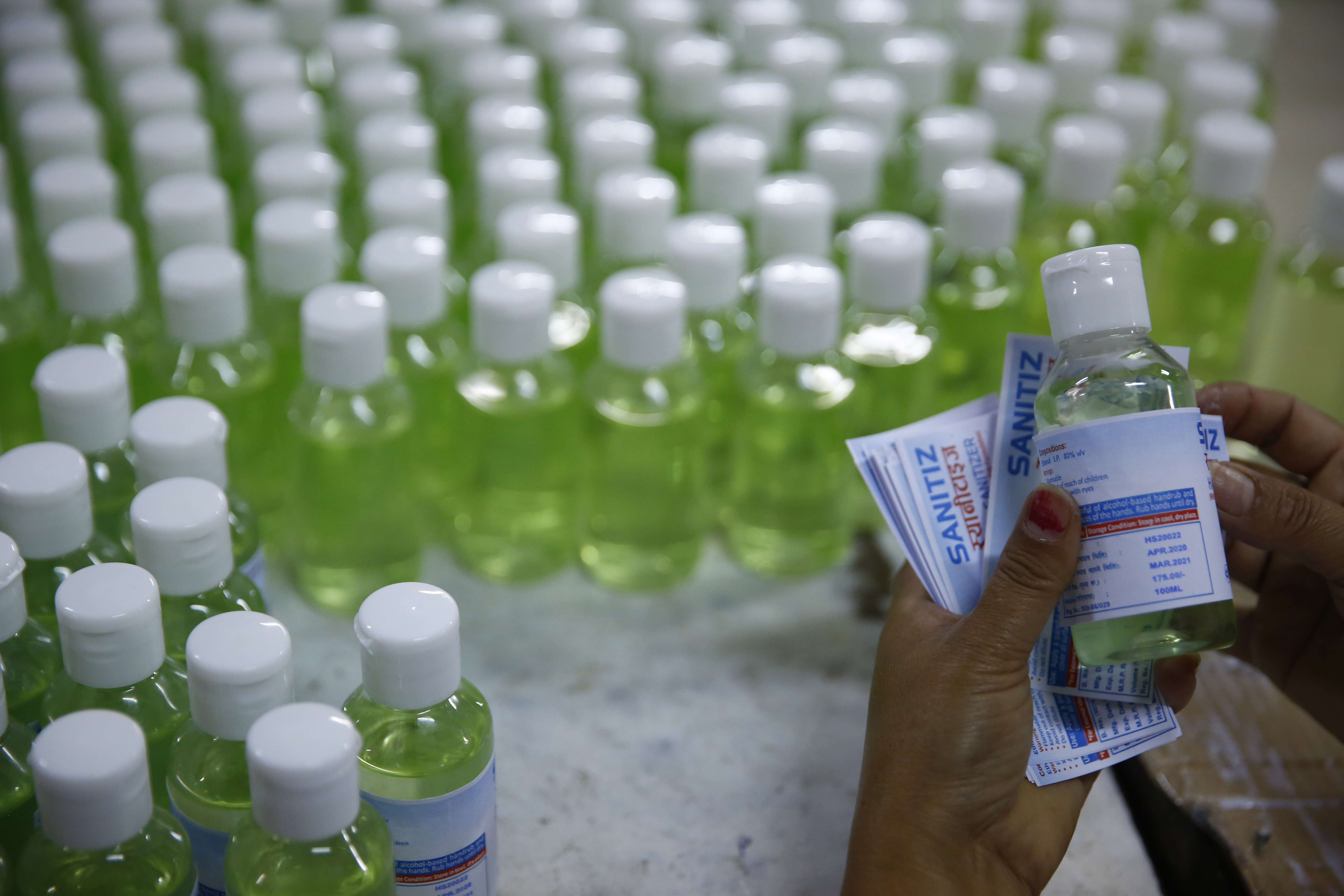 Staffers label hand sanitiser bottles to be sold in the market, at Aushadhi Limited, in Kathmandu, on Tuesday, April 07, 2020. Photo: Skanda Gautam/THT