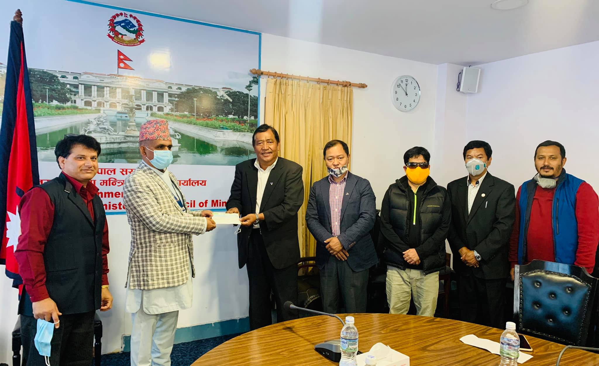 NMA President Santa Bir Lama is handing over cheque to the Mahendra Prasad Guragai. Photo: Nepal Mountaineering Association