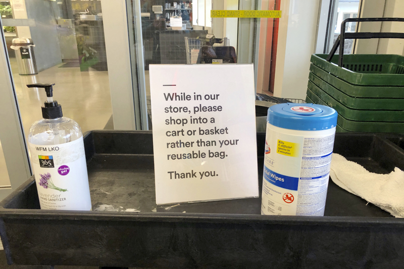 A sign posted at an entrance to a 365 Whole Foods store advises customers not to use their own bags while shopping in Lake Oswego, Oregon, March 29, 2020. Photo: AP