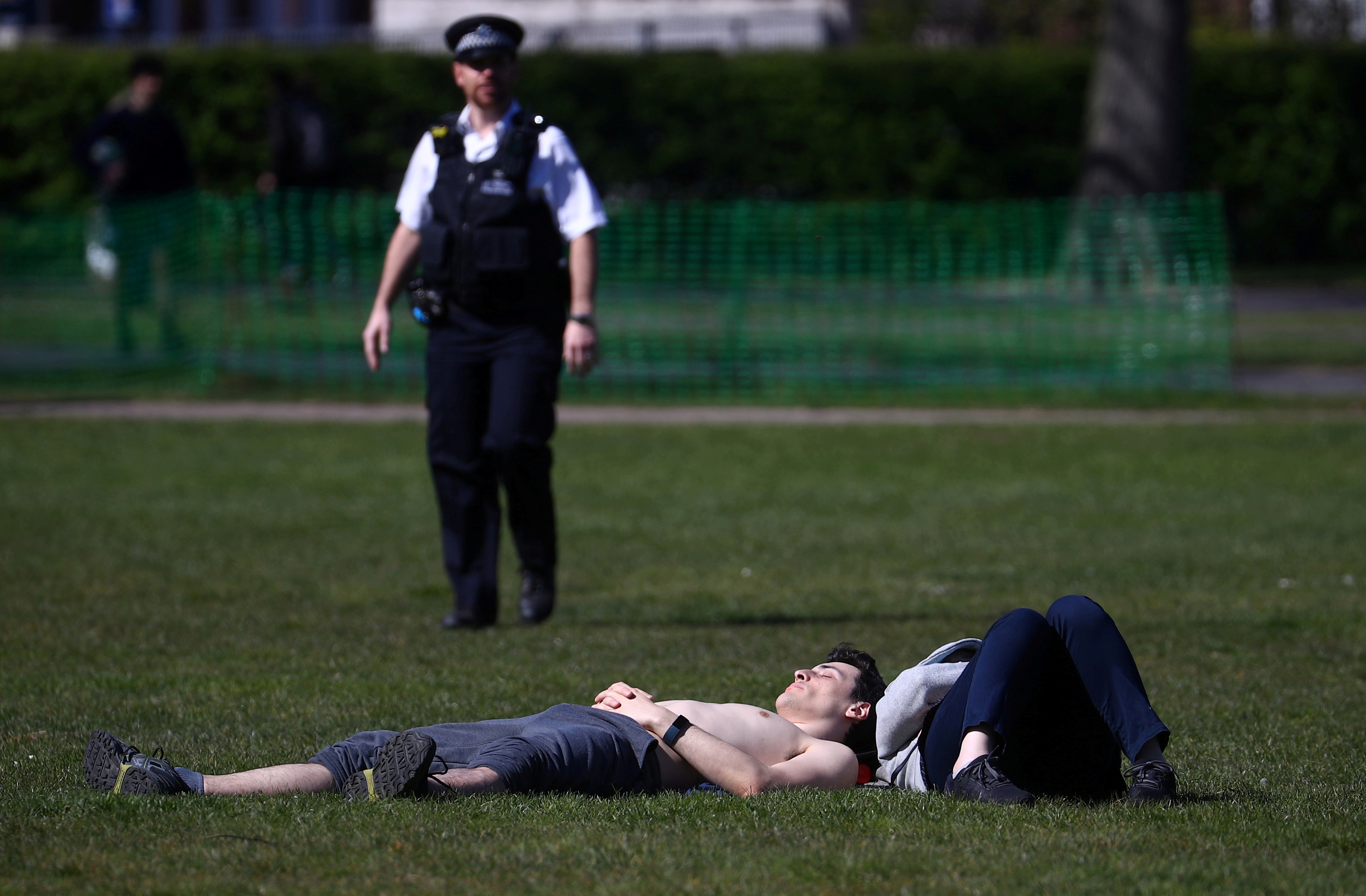 A Police officer with people in Greenwich Park, as the spread of the coronavirus disease (COVID-19) continues, London, Britain, on April 4, 2020. Photo: Reuters
