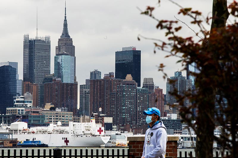 A man wears a face mask while the USNS Comfort and the Empire State Building are seen from Weehawken, New Jersey, during the outbreak of the coronavirus disease (COVID-19) in New York City, US, March 31, 2020. Photo: Reuters