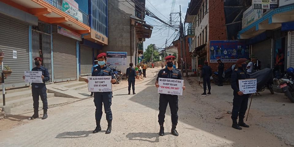 Police personnel display placards to urge people to stay at home, targeting those defying the government-imposed nationwide lockdown, in the wake of coronavirus contagion, in Bhojpur district, on Friday, April 10, 2020. Photo: Niroj Koirala/THT