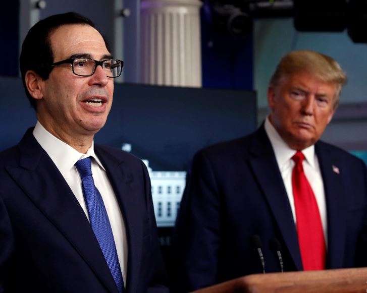 In this April 13, 2020, file photo President Donald Trump listens as Treasury Secretary Steven Mnuchin speaks about the coronavirus in the James Brady Press Briefing Room at the White House in Washington. The Trump administration and Congress are nearing an agreement as early as Sunday, April 19, on a $400-plus billion aid package to boost a small-business loan program that has run out of money and add funds for hospitals and COVID-19 testing.  File Photo: AP