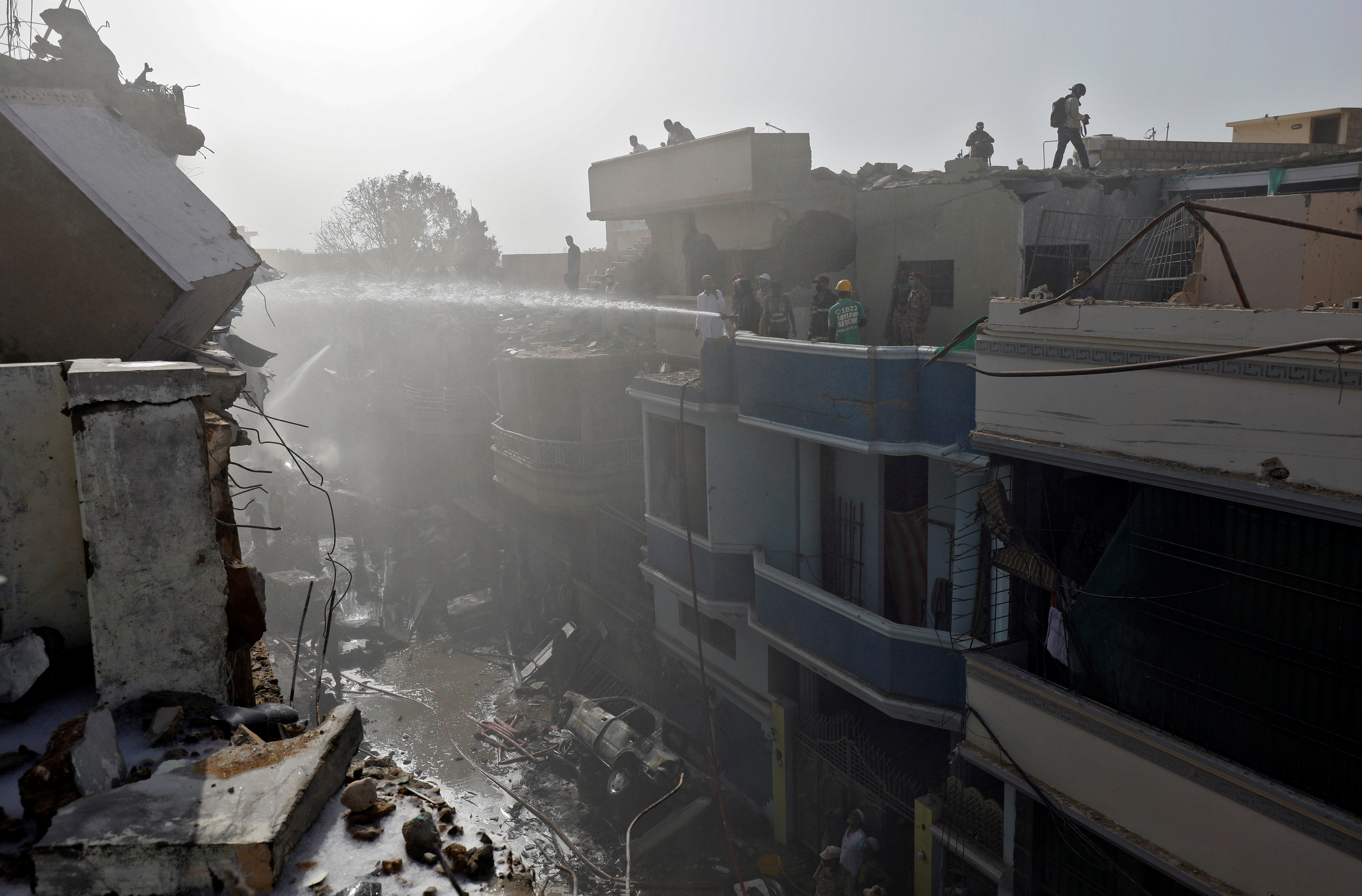 Rescue workers gather at the site of a passenger plane crash in a residential area near an airport in Karachi, Pakistan May 22, 2020. Photo: Reuters