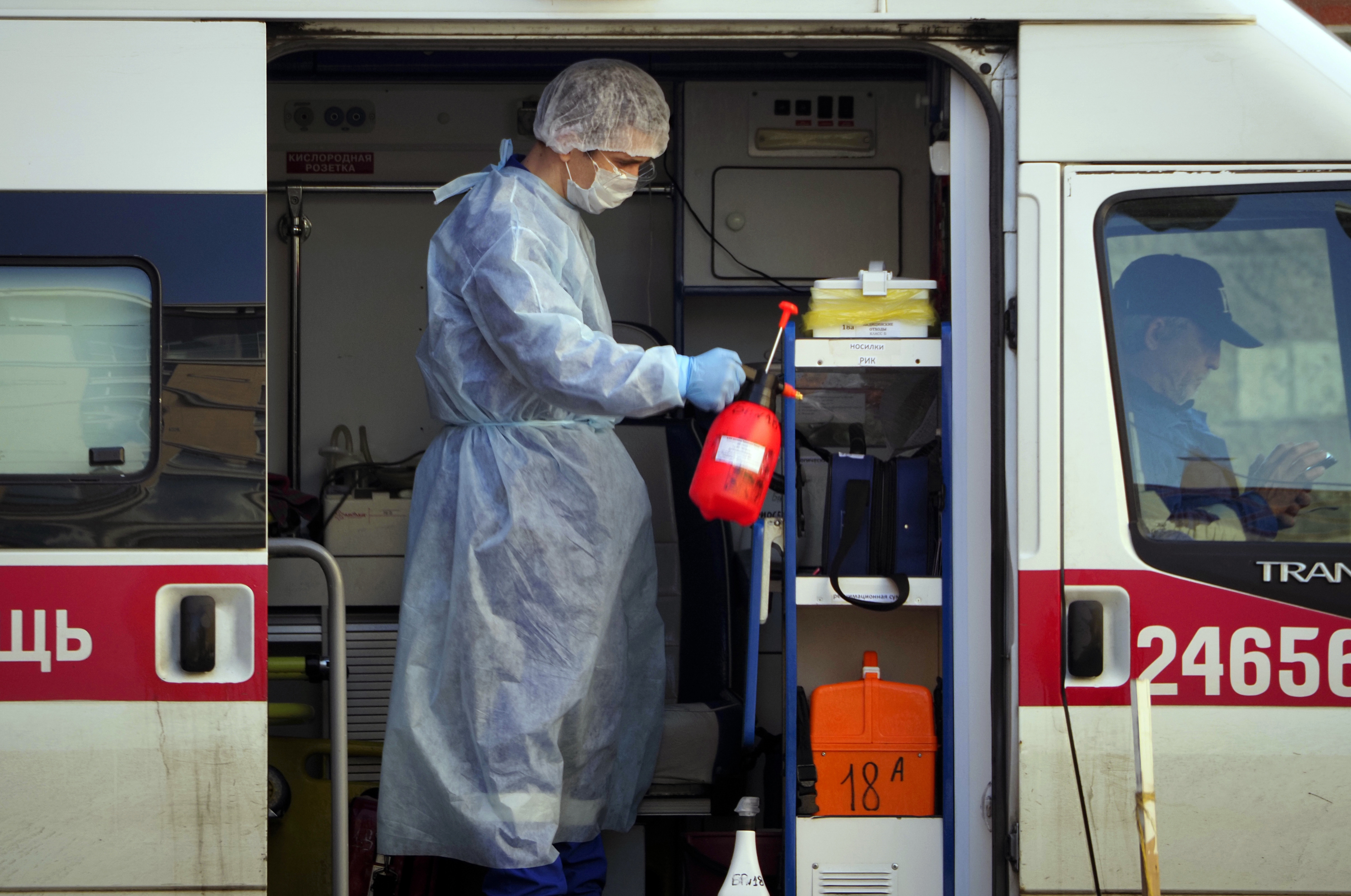 A medical worker wearing protective equipment sprays disinfectant at his ambulance after delivering a patient suspected of being infected with the coronavirus to the Pokrovskaya hospital in St.Petersburg, Russia, Monday, May 4, 2020.Photo: AP